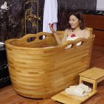 wooden bathtub with handrails and headset