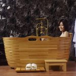 wooden bathtub with handrails and headset